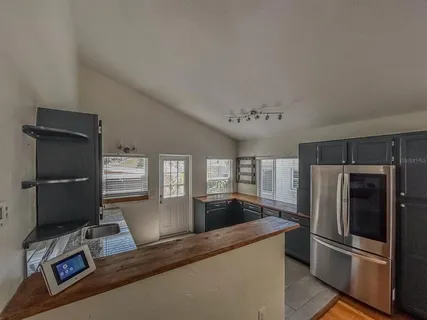 a kitchen with granite countertop a refrigerator and a sink