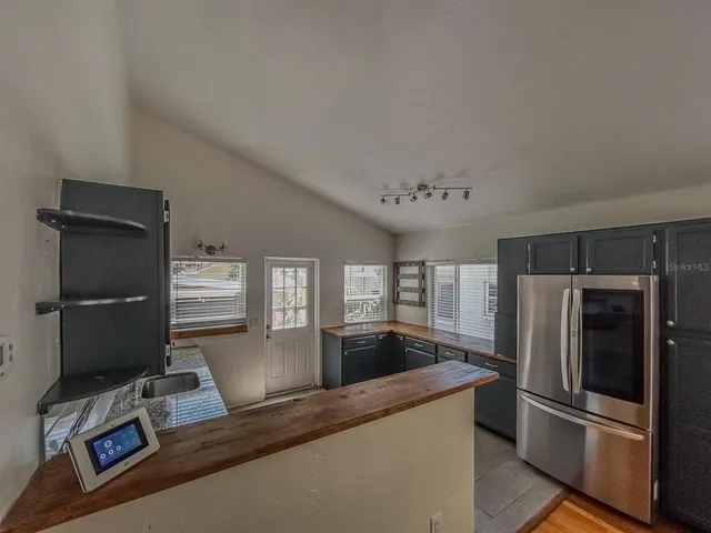 a kitchen with granite countertop a refrigerator and a sink