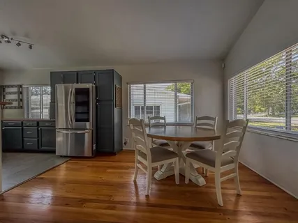 a dining room with furniture and wooden floor