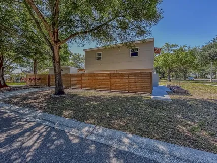a view of a wooden house with a large tree
