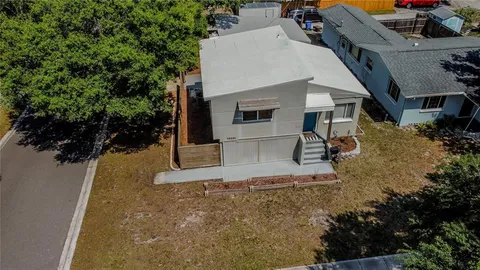 a view of a white house with large trees