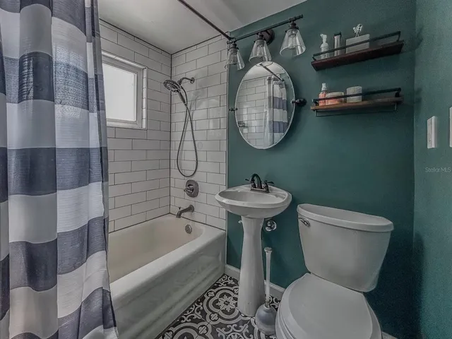 a bathroom with a sink mirror bathtub and toilet