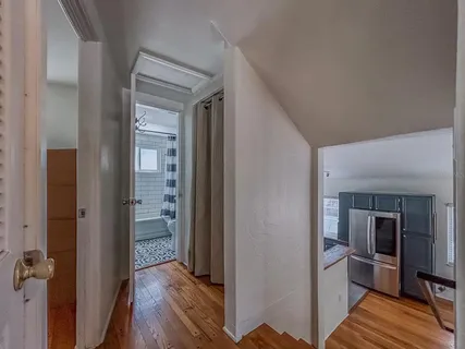 a view of a hallway with wooden floor and furniture