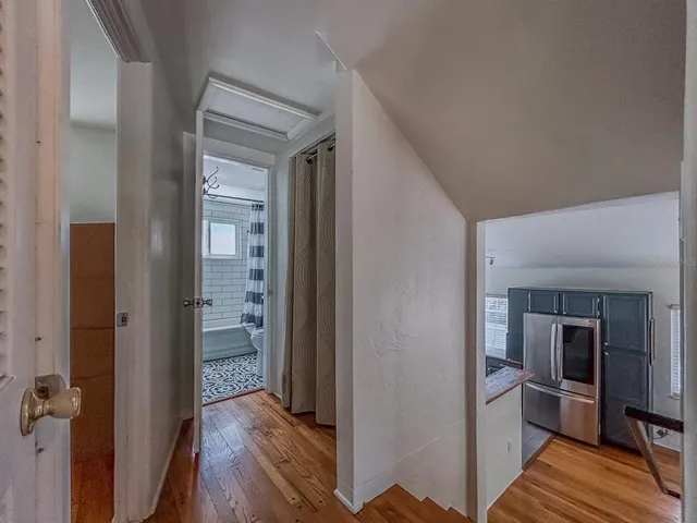a view of a hallway with wooden floor and furniture