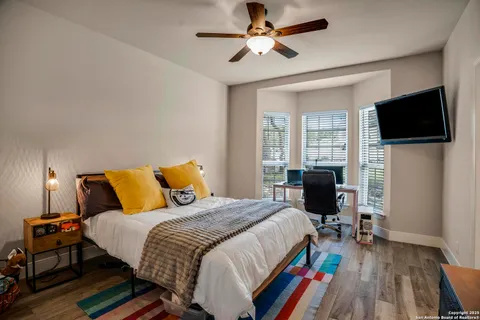 a bed room with a bed a flat screen tv and a window