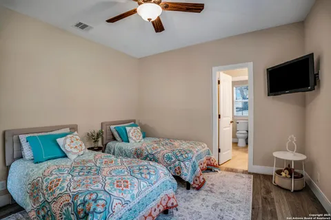 a bedroom with two beds and a flat screen tv