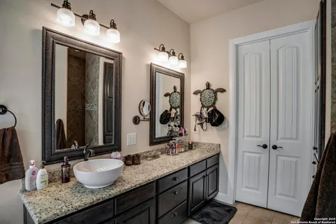 a bathroom with double vanity sinks and a mirror