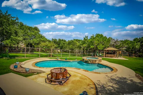 a view of a swimming pool with a yard and plants
