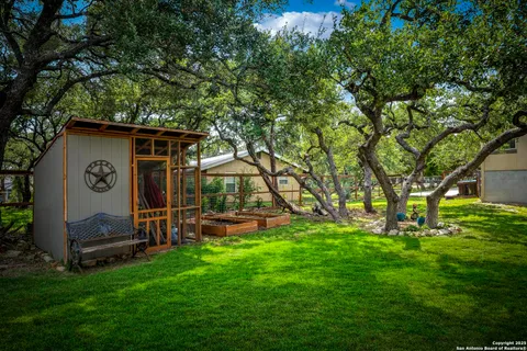 a view of a house with backyard and a tree