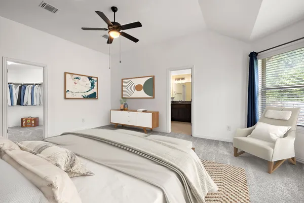 a spacious bedroom with a bed couch and a window