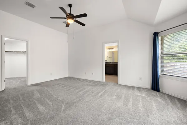 an empty room with fan and windows