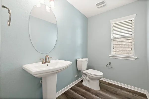 a bathroom with a toilet sink and mirror