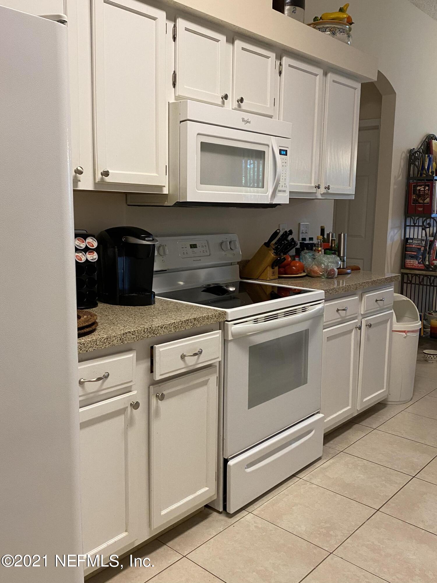 4387 Pebble Brook Drive Jacksonville, FL 32224 - Photo 12 of 30 a kitchen with white cabinets and white appliances