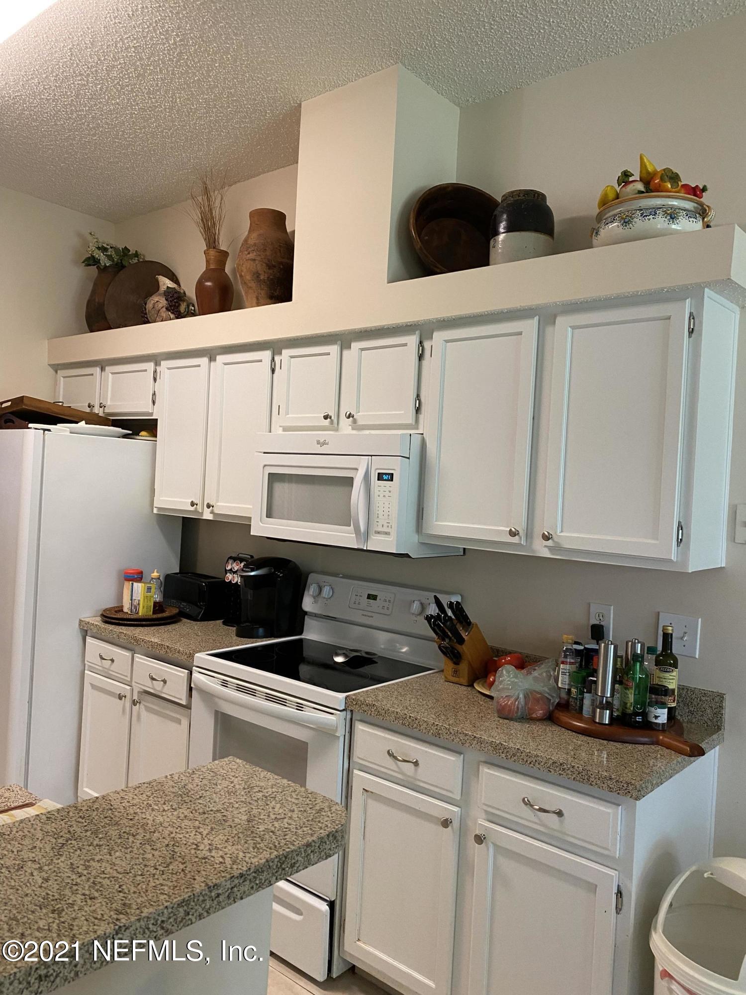 4387 Pebble Brook Drive Jacksonville, FL 32224 - Photo 13 of 30 a kitchen with stainless steel appliances granite countertop a stove a sink and white cabinets