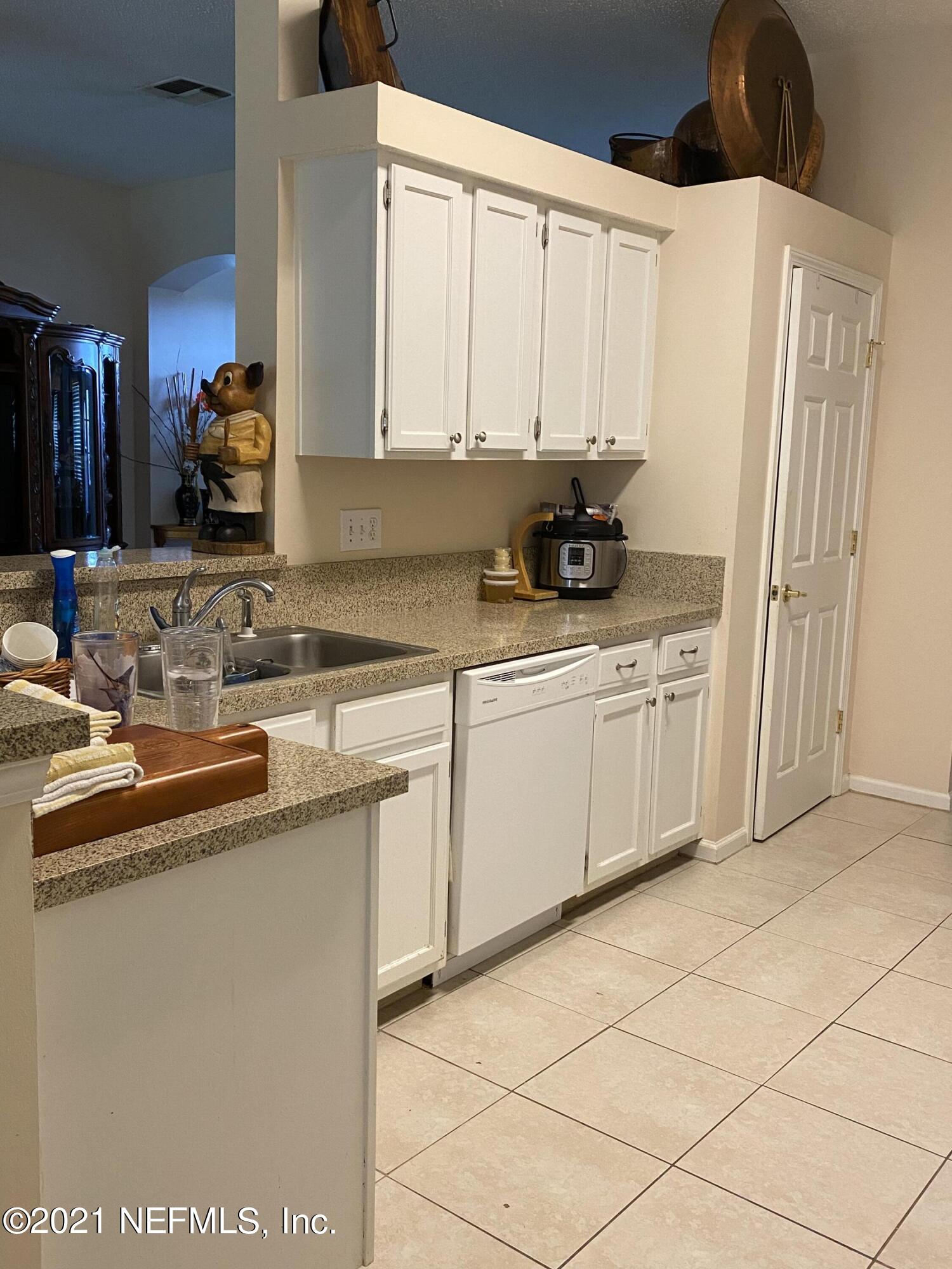 4387 Pebble Brook Drive Jacksonville, FL 32224 - Photo 14 of 30 a kitchen with stainless steel appliances a sink a stove a refrigerator and cabinets