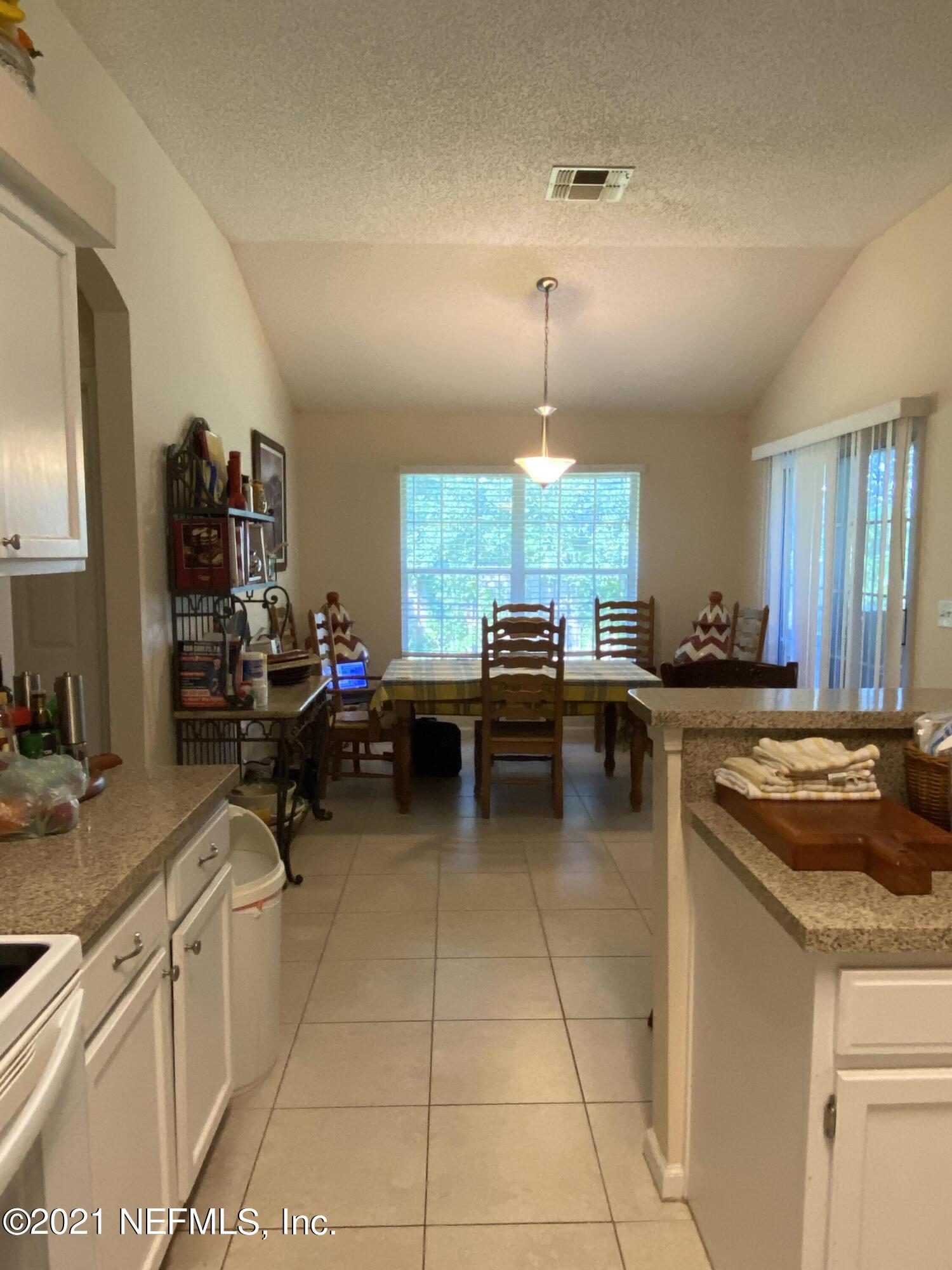 4387 Pebble Brook Drive Jacksonville, FL 32224 - Photo 16 of 30 a kitchen with a stove a sink a counter space and cabinets