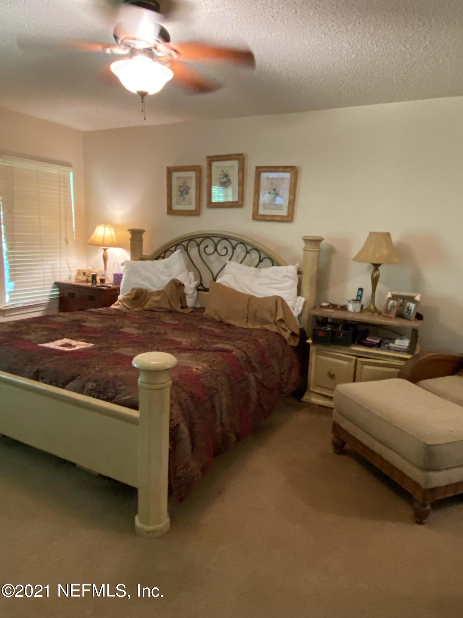 4387 Pebble Brook Drive Jacksonville, FL 32224 - Photo 18 of 30 a spacious bedroom with a bed and lamp