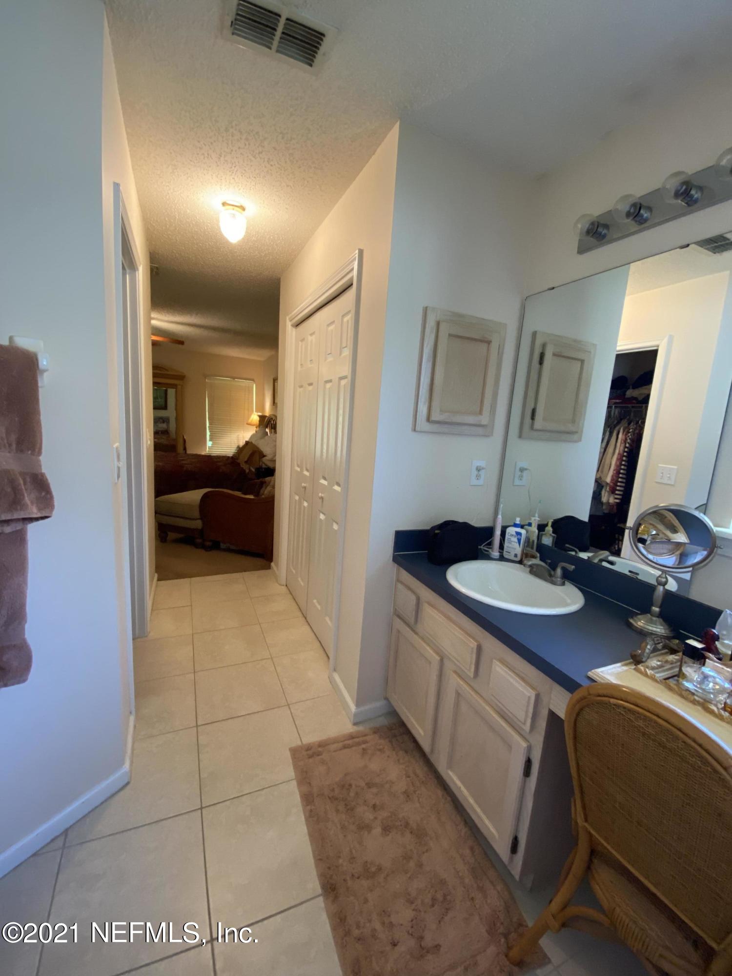 4387 Pebble Brook Drive Jacksonville, FL 32224 - Photo 21 of 30 a en suite bathroom with a granite countertop sink a mirror and a bathtub