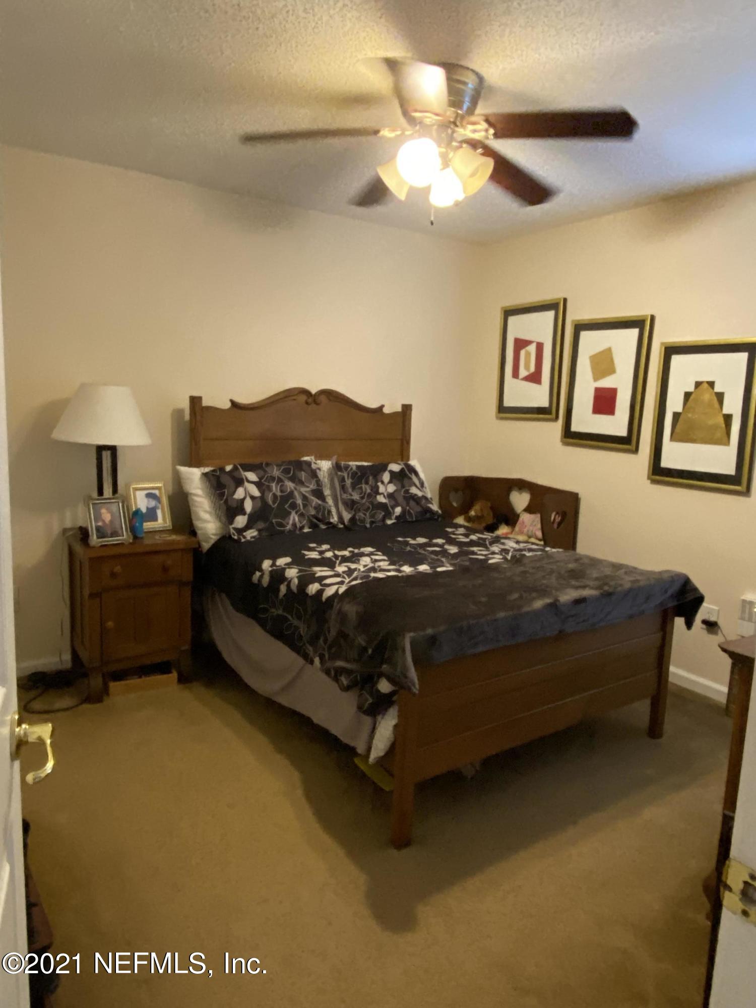 4387 Pebble Brook Drive Jacksonville, FL 32224 - Photo 22 of 30 a bed sitting in a bedroom next to a window