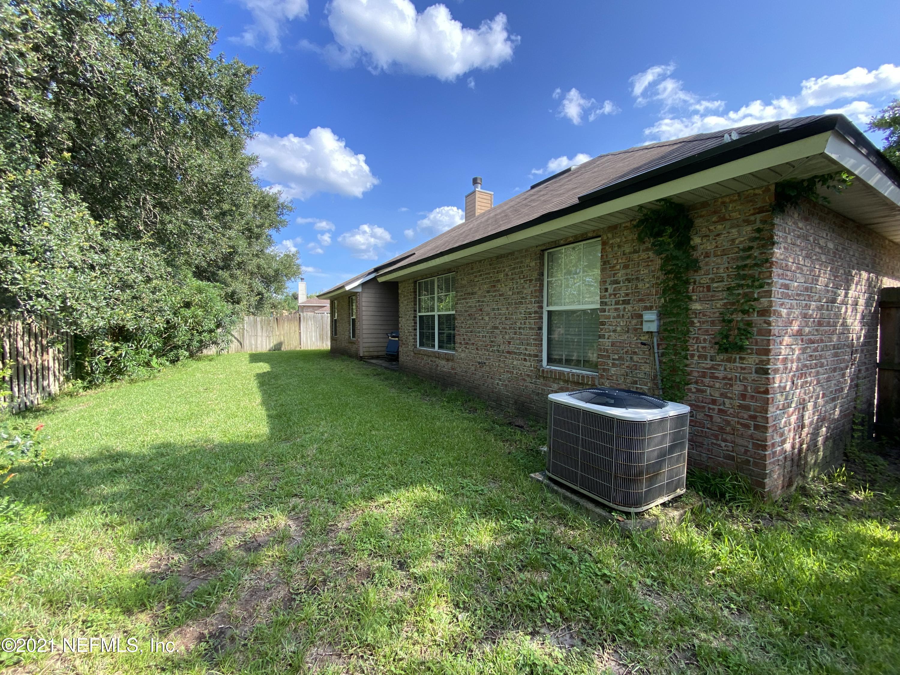 4387 Pebble Brook Drive Jacksonville, FL 32224 - Photo 30 of 30 a backyard of a house with lots of green space