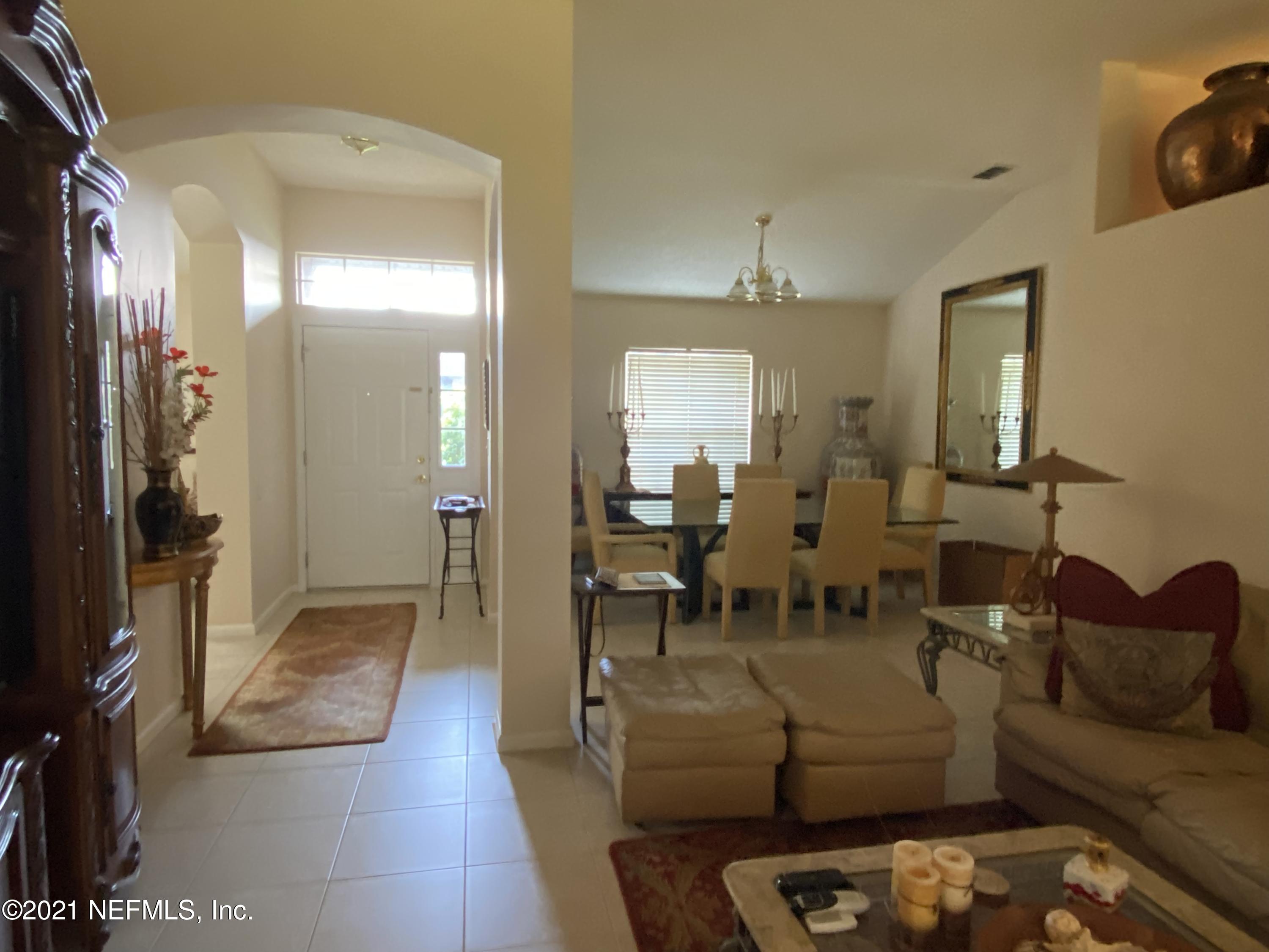 4387 Pebble Brook Drive Jacksonville, FL 32224 - Photo 7 of 30 a living room with furniture and a chandelier