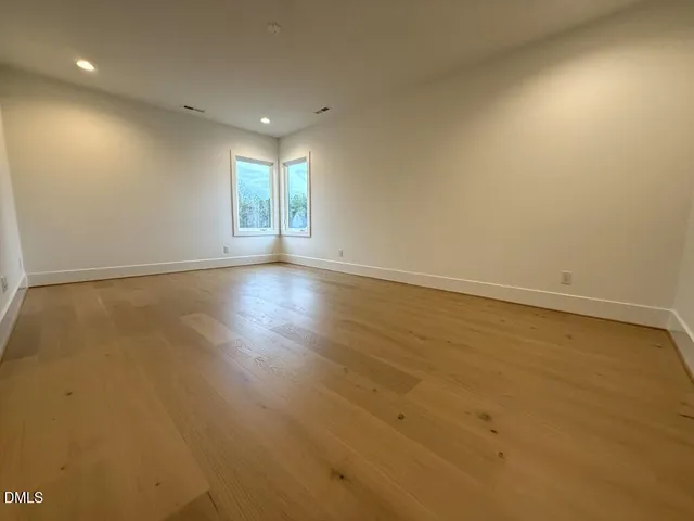 a view of empty room with window and ceiling fan