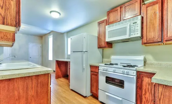 a kitchen with stainless steel appliances granite countertop a stove a sink and a microwave