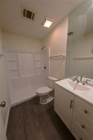 a bathroom with a sink a toilet and shower