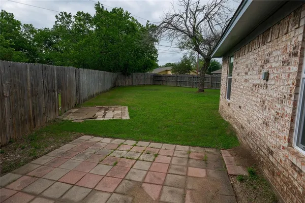 a view of backyard with wooden fence