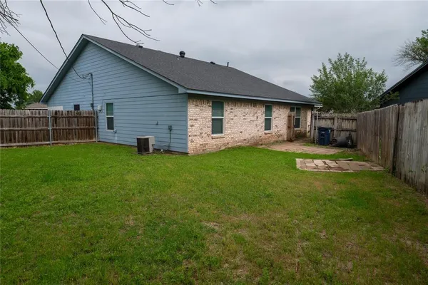a view of a backyard with table and chairs and wooden fence