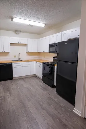 a kitchen with granite countertop a refrigerator stove top oven and sink