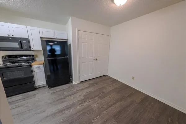 a kitchen with a refrigerator stove and white cabinets