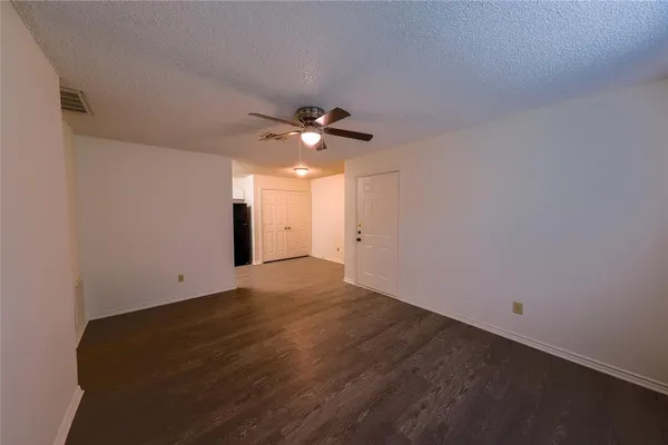 an empty room with a ceiling fan and a window