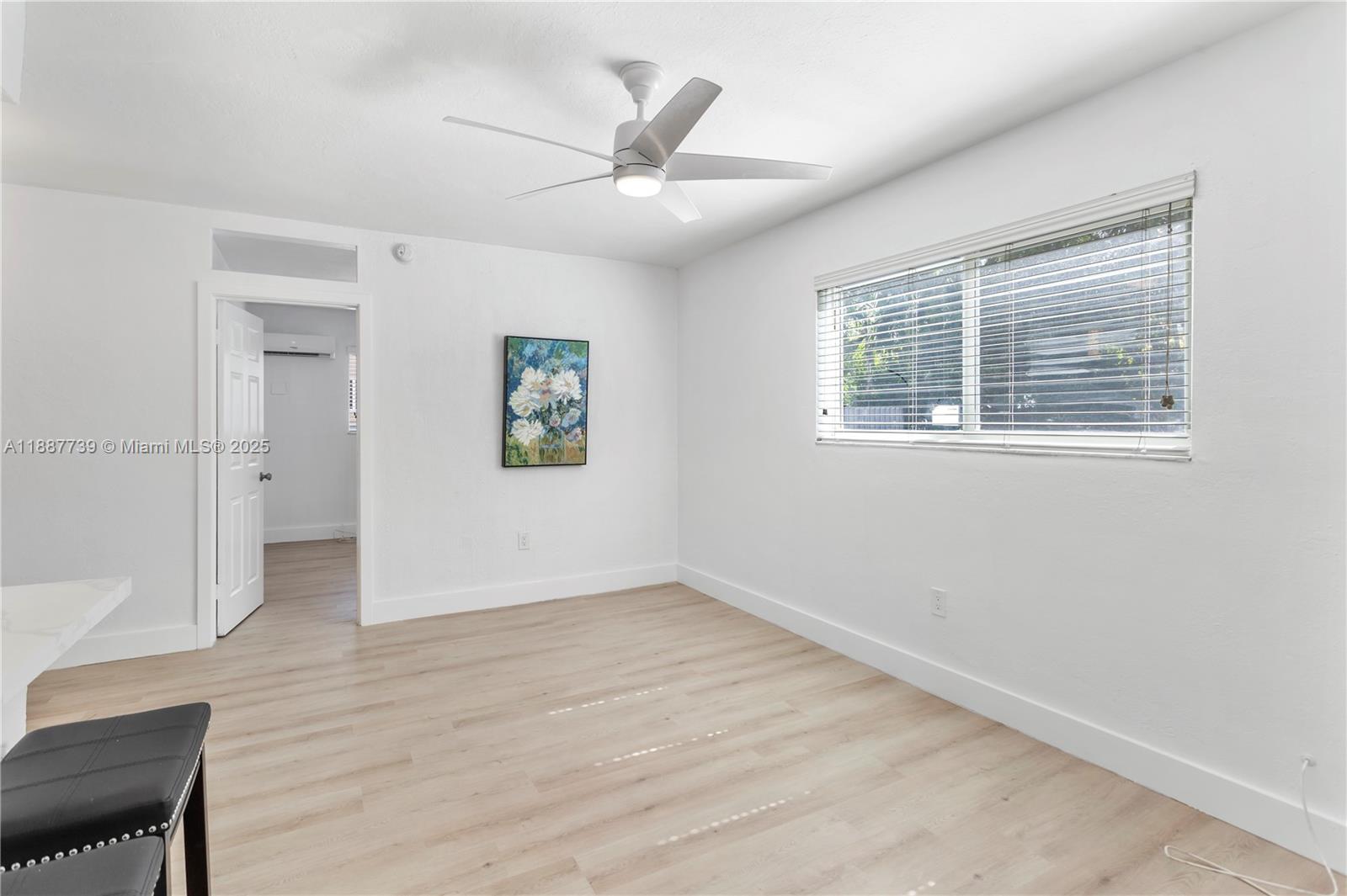 6330 Southwest 79th Street, Unit 5 South Miami, FL 33143 - Photo 1 of 19 an empty room with wooden floor a ceiling fan and windows