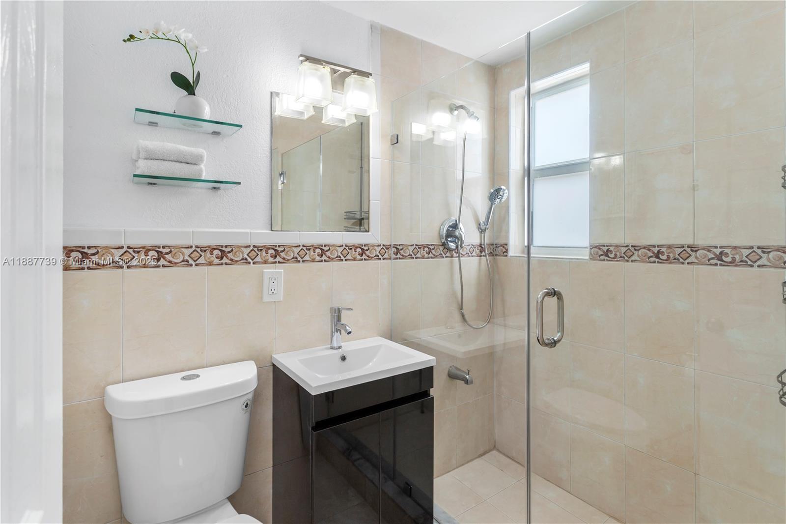 6330 Southwest 79th Street, Unit 5 South Miami, FL 33143 - Photo 12 of 19 a bathroom with a toilet sink and mirror