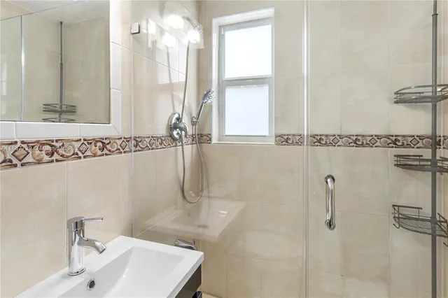 a bathroom with a sink a mirror and shower