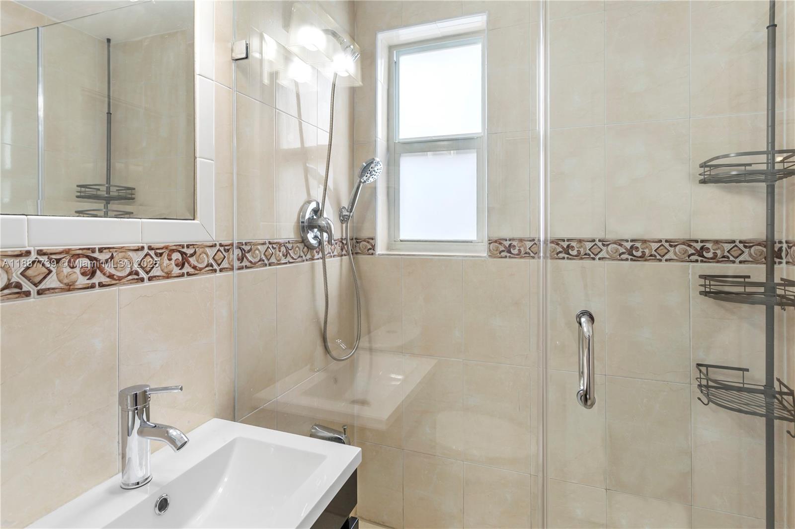 6330 Southwest 79th Street, Unit 5 South Miami, FL 33143 - Photo 13 of 19 a bathroom with a sink a mirror and shower