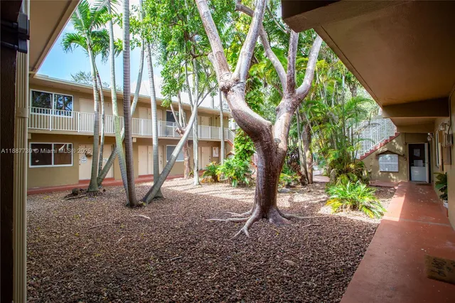 a view of an house with backyard and trees