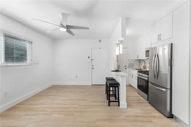 a kitchen with stainless steel appliances a refrigerator a stove a sink dishwasher and a refrigerator with wooden floor