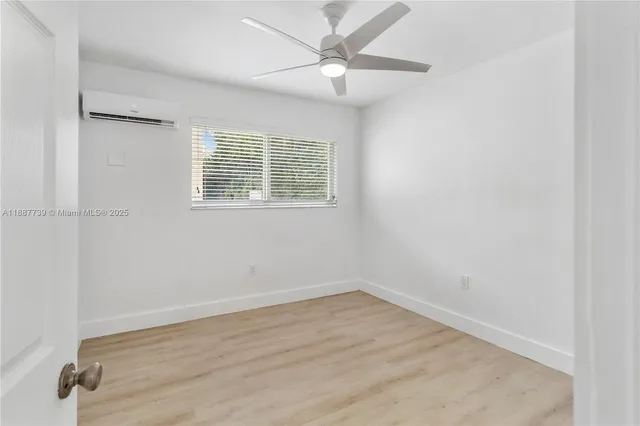 an empty room with a window and a ceiling fan