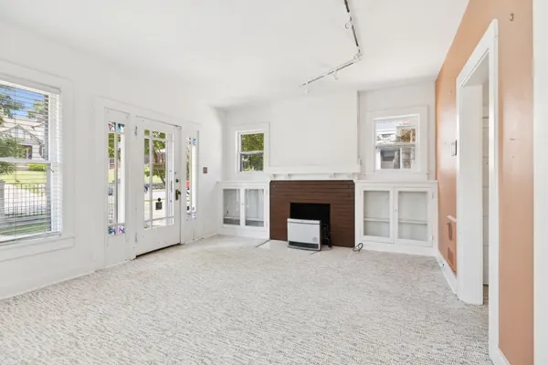 a view of an empty room with a fireplace and a window