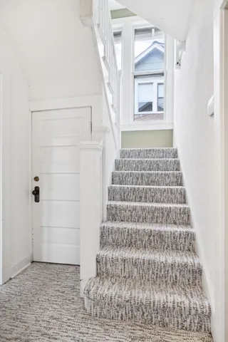 a view of a hallway with wooden floor and entryway