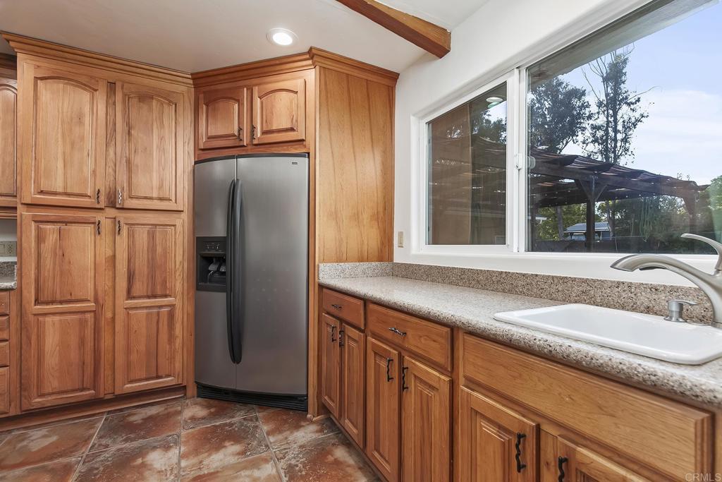 10546 Valle Vista Road Lakeside, CA 92040 - Photo 11 of 66 a kitchen with granite countertop a refrigerator and cabinets