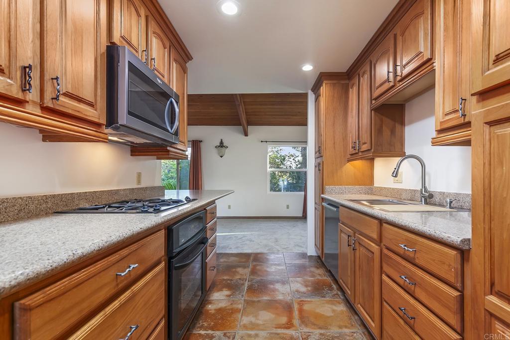 10546 Valle Vista Road Lakeside, CA 92040 - Photo 13 of 66 a kitchen with stainless steel appliances granite countertop a stove a sink and a microwave