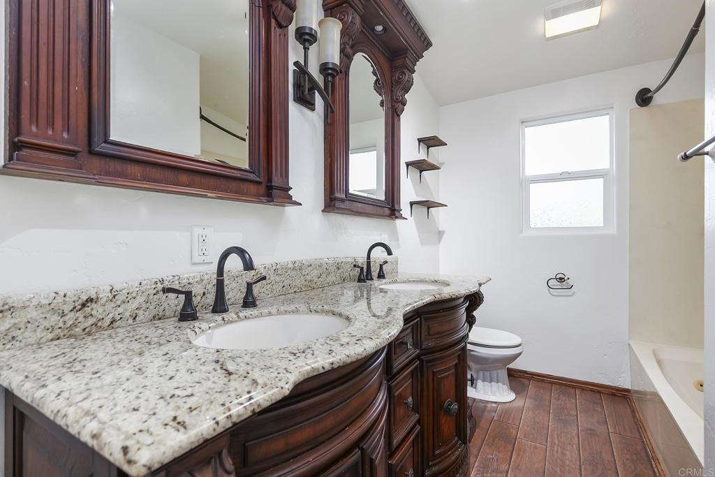 10546 Valle Vista Road Lakeside, CA 92040 - Photo 17 of 66 a bathroom with a granite countertop sink a toilet and mirror