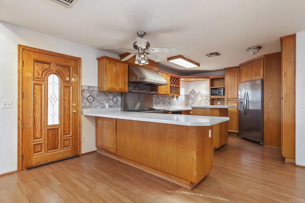 10546 Valle Vista Road Lakeside, CA 92040 - Photo 44 of 66 a kitchen with stainless steel appliances granite countertop a refrigerator a sink dishwasher a stove and a refrigerator with wooden floor