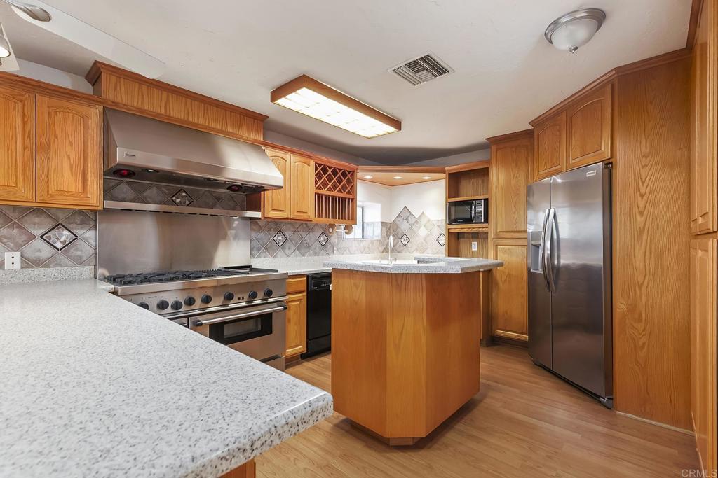 10546 Valle Vista Road Lakeside, CA 92040 - Photo 45 of 66 a kitchen with stainless steel appliances granite countertop a stove a sink and a refrigerator