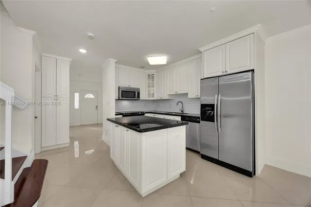 a kitchen with granite countertop a refrigerator and a sink