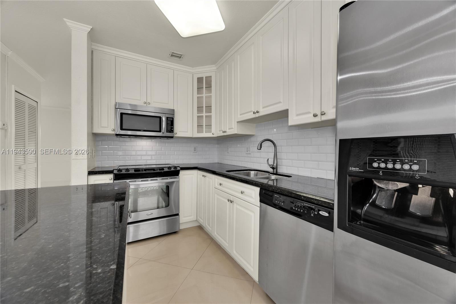 7773 Southwest 94th Lane Miami, FL 33156 - Photo 40 of 50 a kitchen with granite countertop white cabinets and stainless steel appliances
