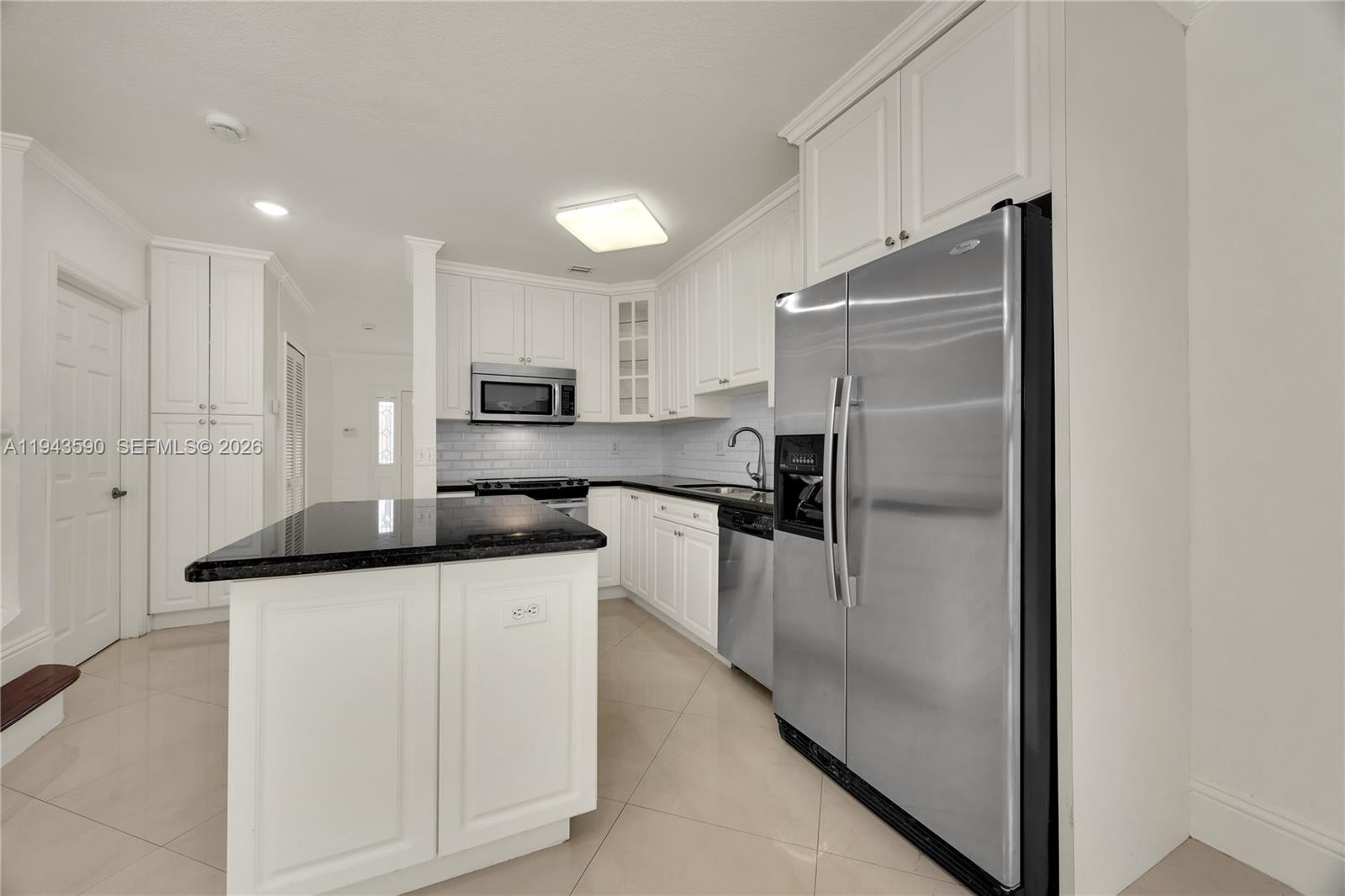 7773 Southwest 94th Lane Miami, FL 33156 - Photo 41 of 50 a kitchen with granite countertop a refrigerator and a sink